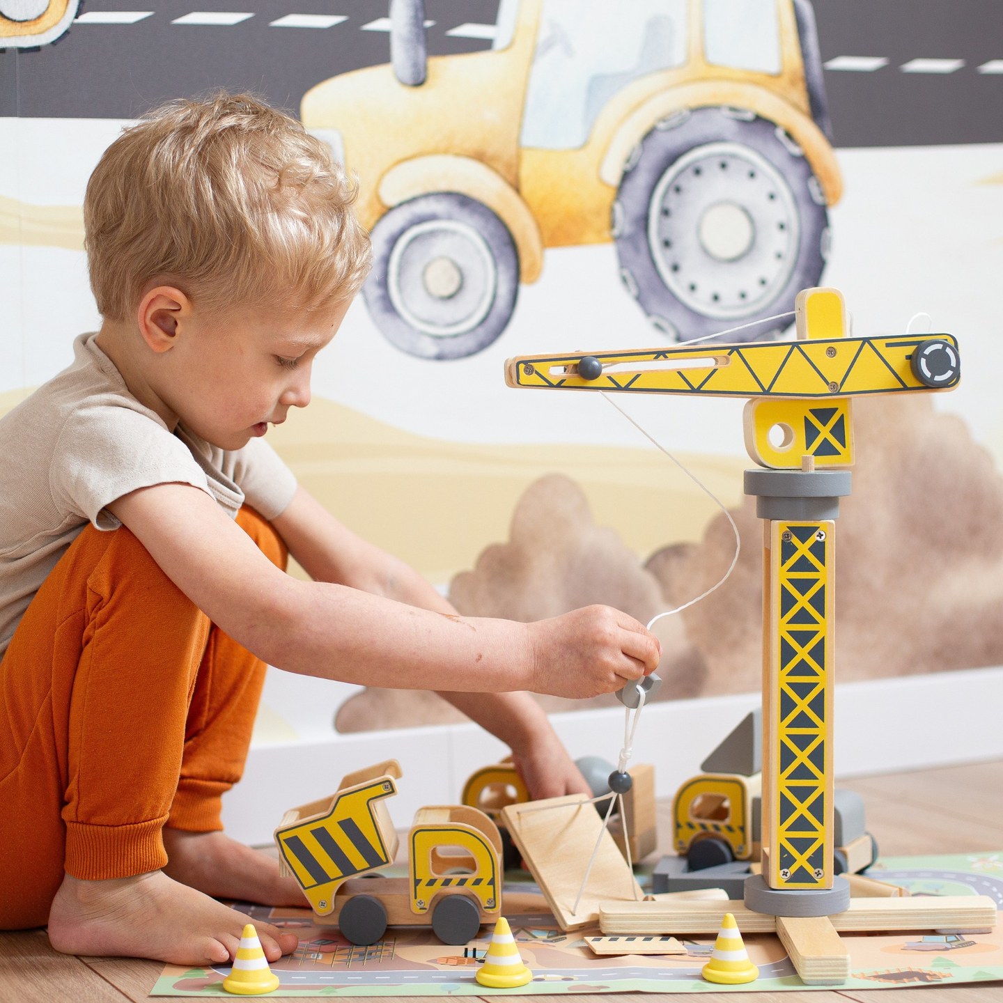 Medinė statybų aikštelė su dideliu mobiliuoju kranu ir transporto priemonėmis, bokštinis kranas