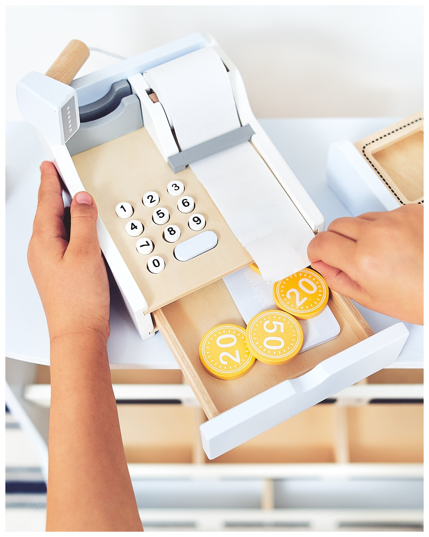 Daržovių parduotuvė - medinis prekystalis su dėžėmis, kasos aparatu ir terminalu