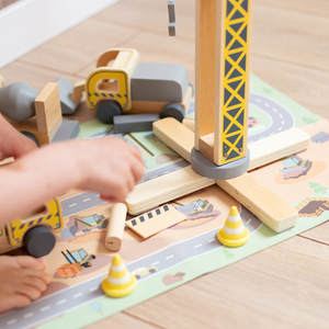 Medinė statybų aikštelė su dideliu mobiliuoju kranu ir transporto priemonėmis, bokštinis kranas