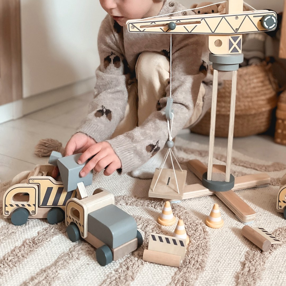 Medinė statybų aikštelė su dideliu mobiliuoju kranu ir transporto priemonėmis, bokštinis kranas