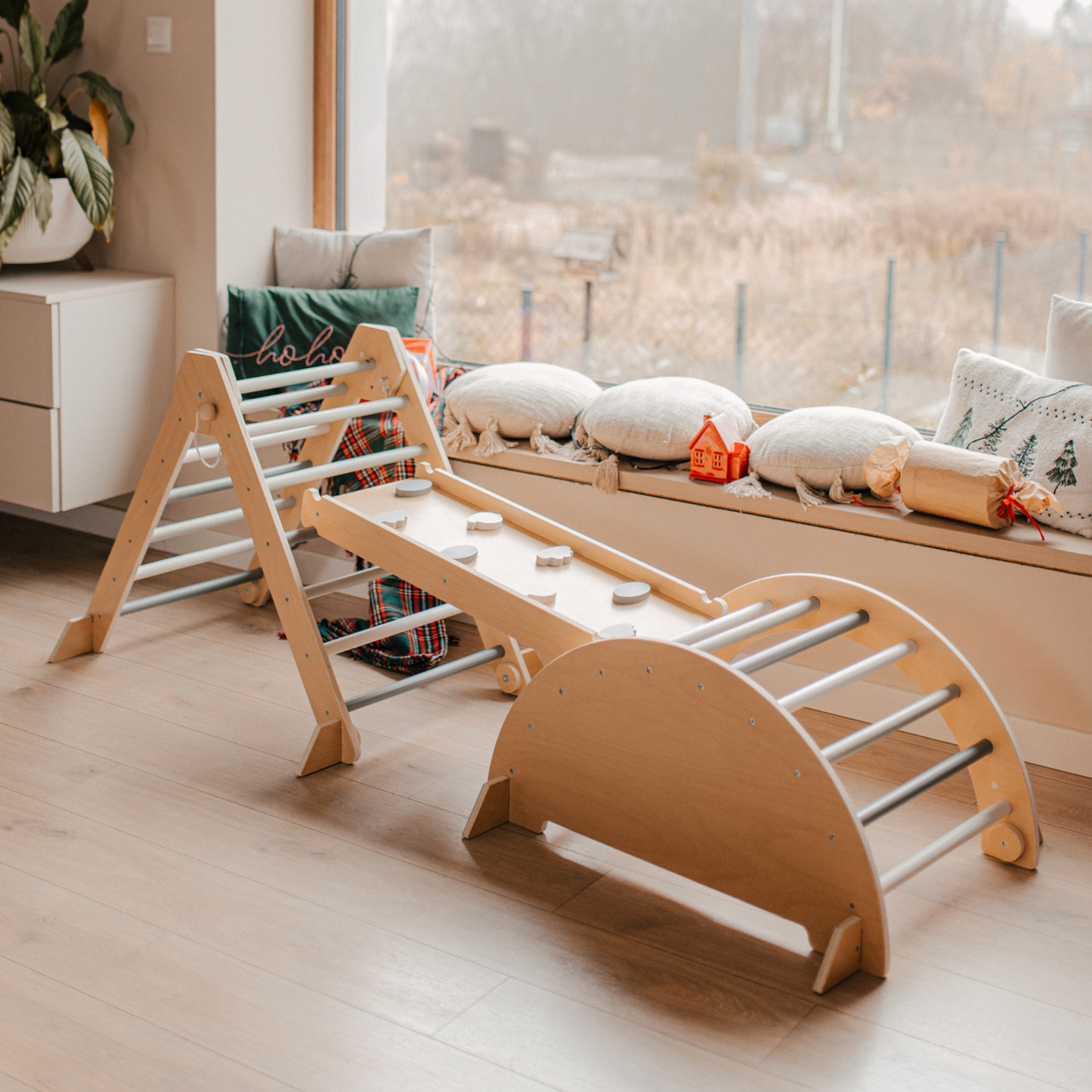 Medinė vaikų žaidimų aikštelė viduje – laipiojimo siena, čiuožykla, laipiojimo arka/suptuvėlė ir Piklerio trikampis