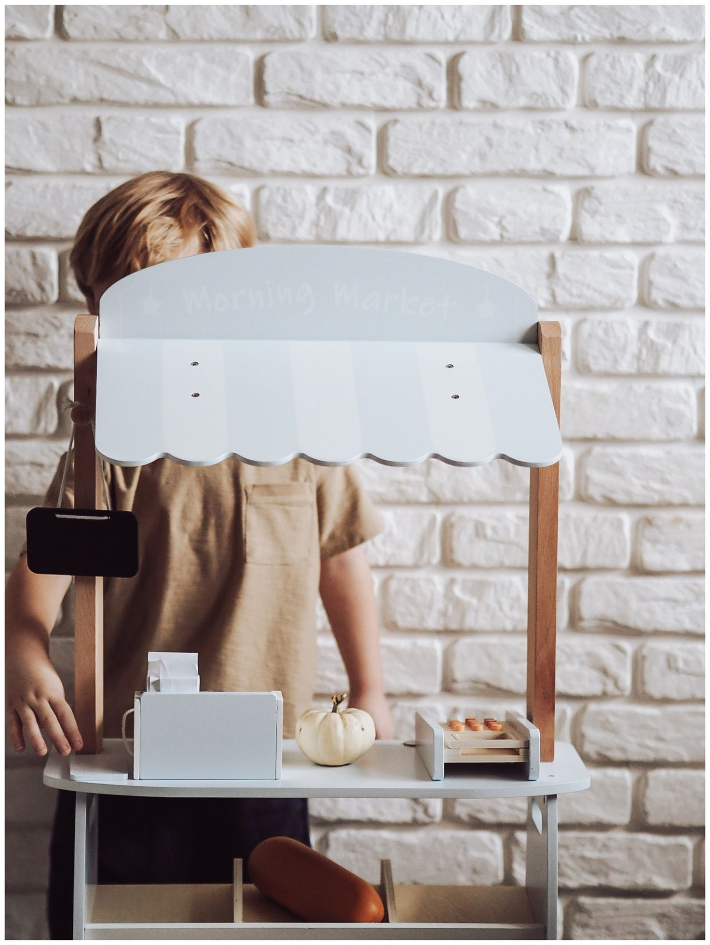 Daržovių parduotuvė - medinis prekystalis su dėžėmis, kasos aparatu ir terminalu